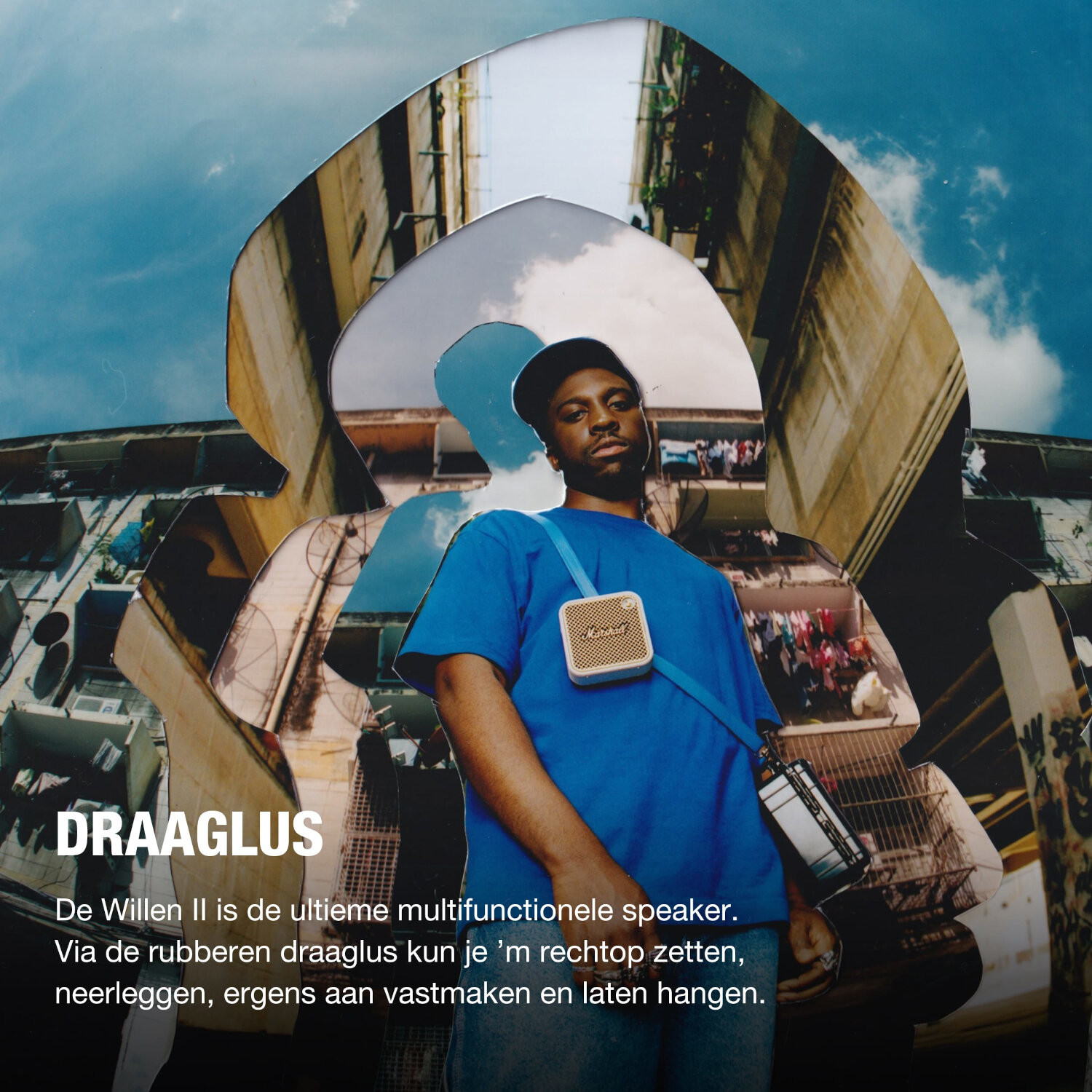 Man met een blauw shirt en een Marshall-luidspreker. Gebouwen en lucht op de achtergrond.