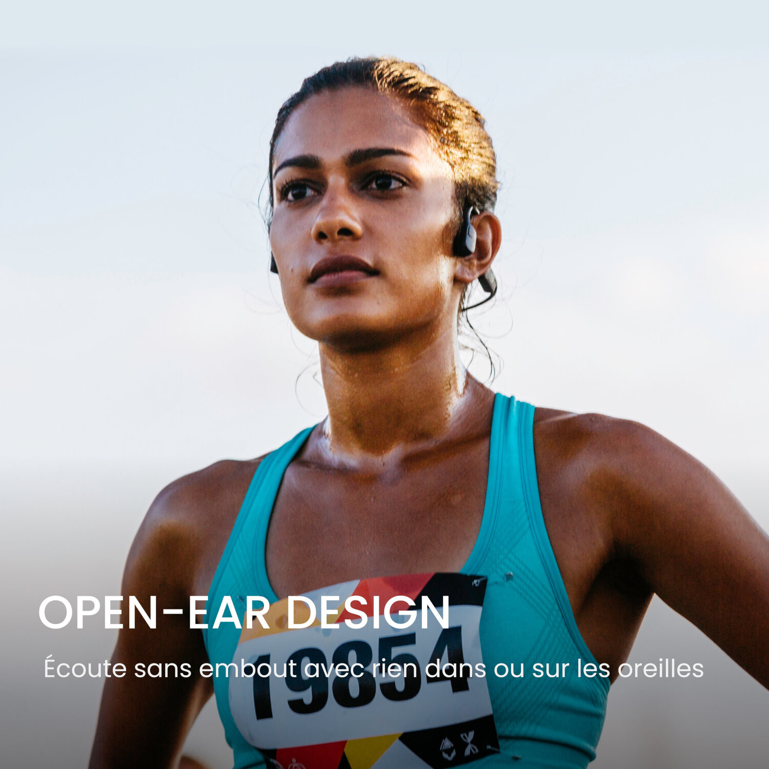 Une coureuse avec des écouteurs à conduction osseuse, focus sur son visage. Texte : OPEN-EAR DESIGN.