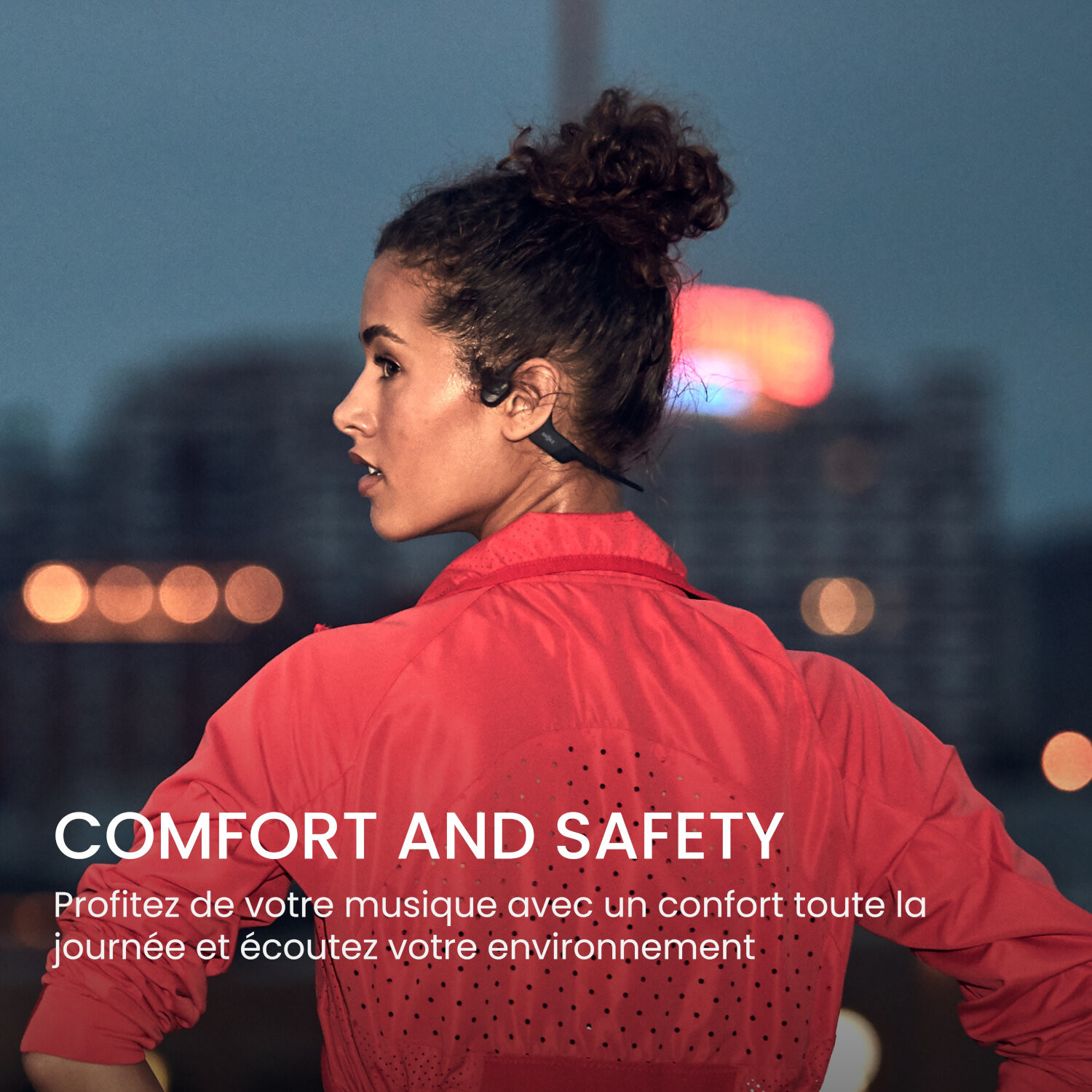 Une femme avec des écouteurs, veste rouge, regardant vers la gauche. Fond de nuit.