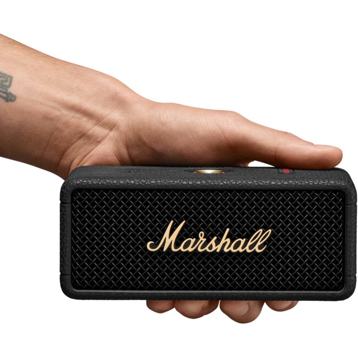 A hand holding a black Marshall speaker with gold logo.