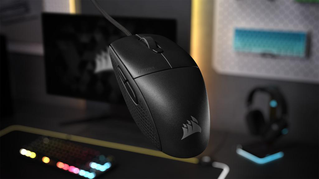 Eine schwarze Gaming-Maus mit Logo, eine Tastatur und ein Monitor auf dem Schreibtisch.