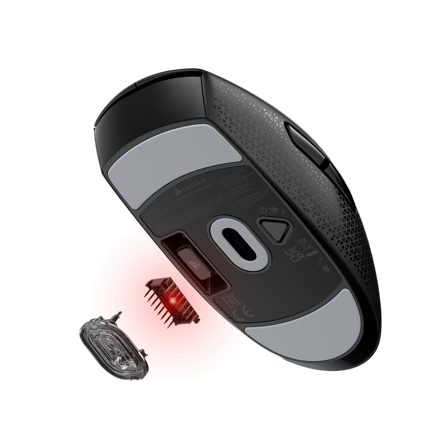 Black gaming mouse with gray accents, bottom view, showing internal components and a detached sensor.