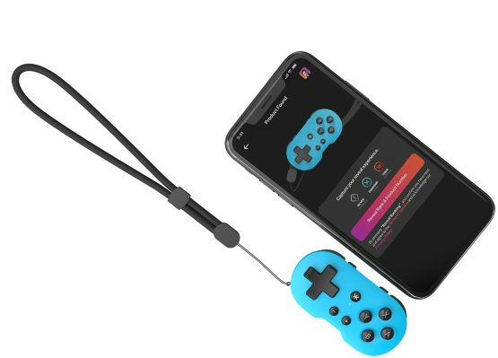 Ein blauer Gamecontroller auf einer weißen Oberfläche, neben einem Telefon, das eine Spieloberfläche anzeigt.
