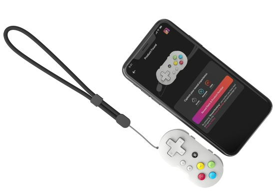 Ein Smartphone, das über einen schwarzen Riemen mit einem kleinen weißen Gamepad verbunden ist.