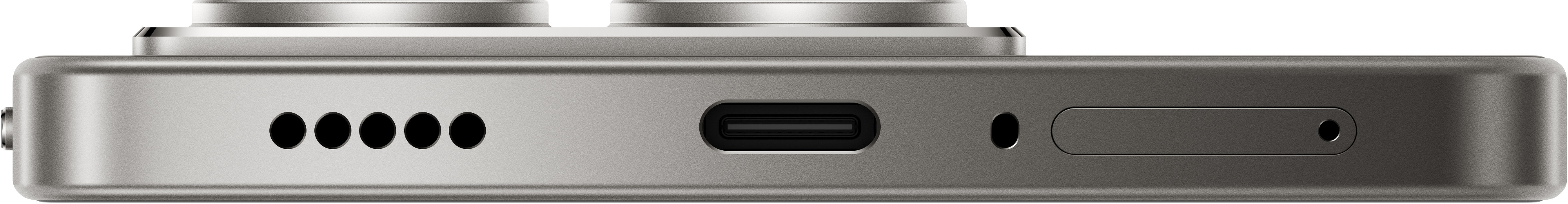 Zbliżenie srebrnego telefonu pokazującego port ładowania, głośniki i inne funkcje.