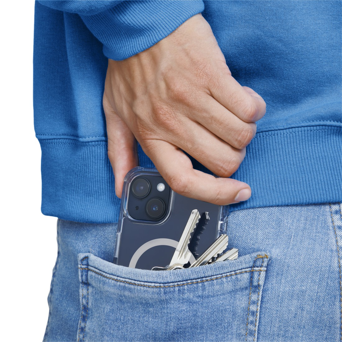 Hand in blauem Hoodie hält ein Telefon in einer Hülle. Schlüssel in der Tasche.