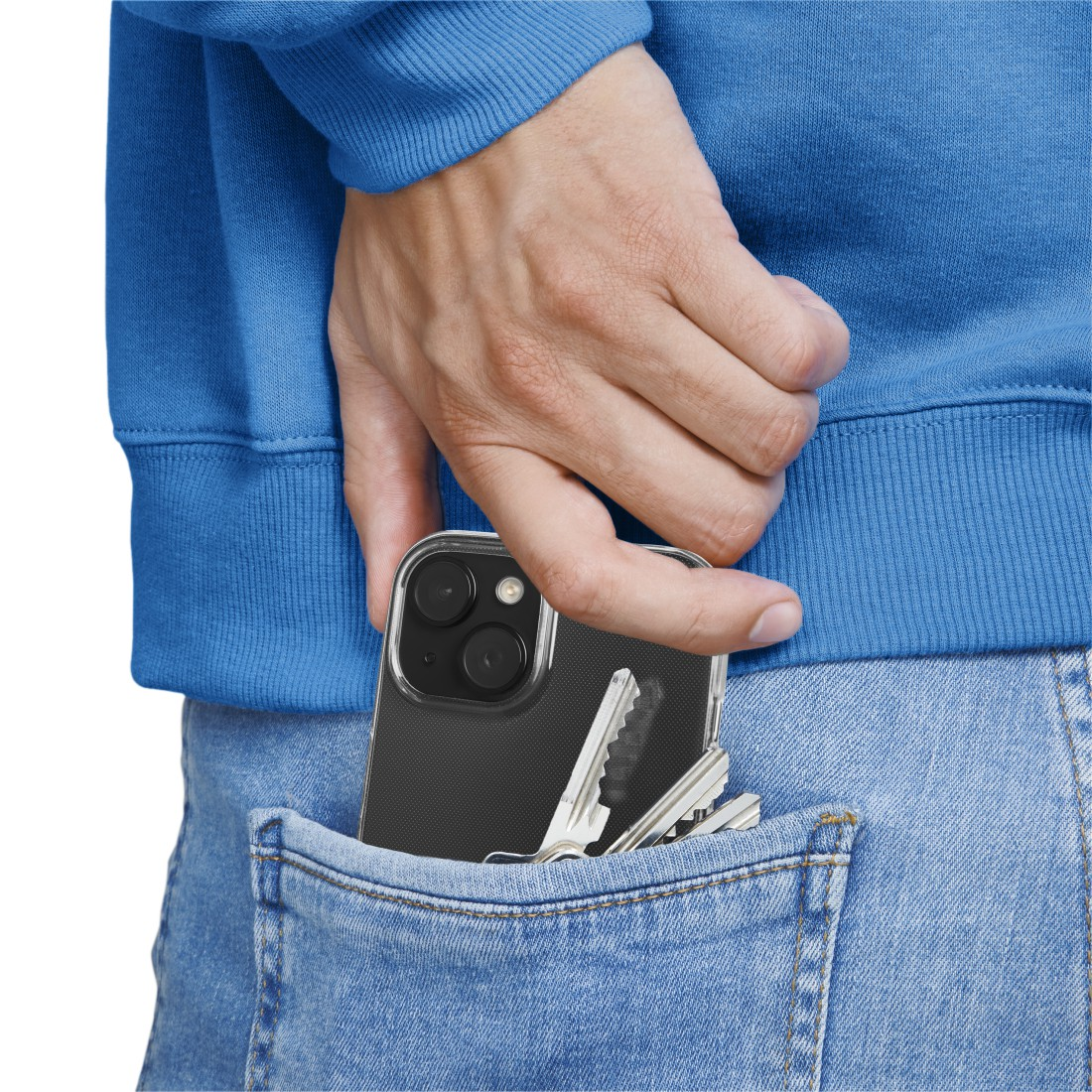 Eine Hand, die ein Telefon in eine Jeanstasche legt, ein Schlüsselbund befindet sich ebenfalls in der Tasche.