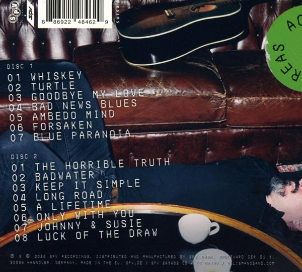 Das Albumcover zeigt ein CD-Case mit Titellisten und eine Gitarre auf einem Ledersofa.