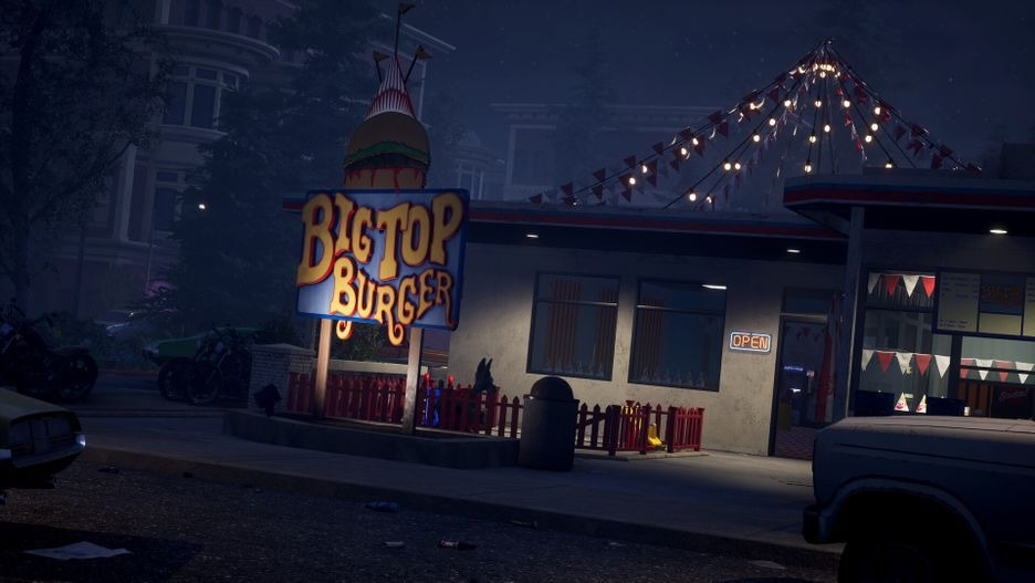 Een Big Top Burger-restaurant 's nachts, met een verlicht bord en een oldtimer ervoor.