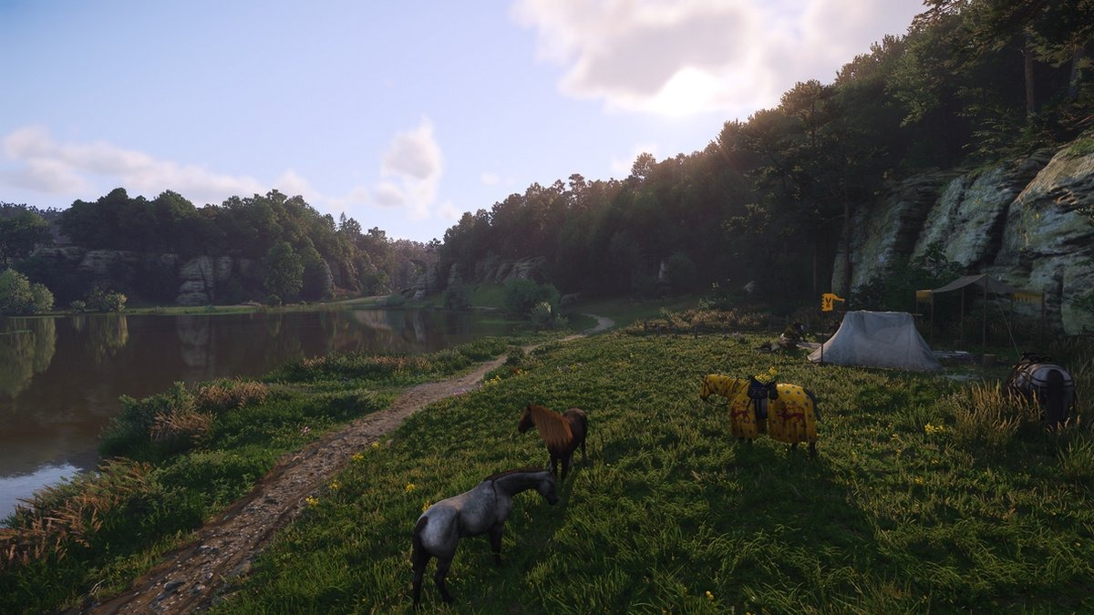 Een landschap met paarden die grazen bij een meer en een kamp op de achtergrond.