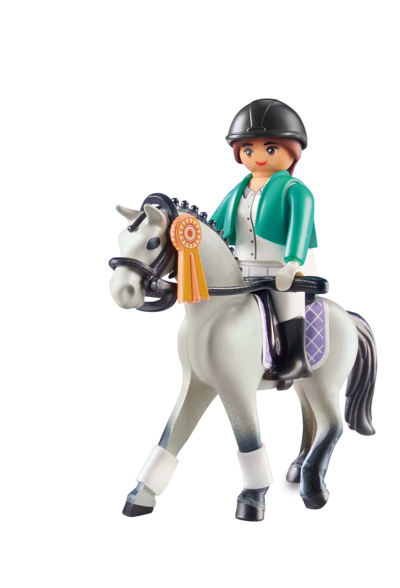 Eine Spielfigur einer Frau, die ein weißes Pferd mit Schleife reitet.