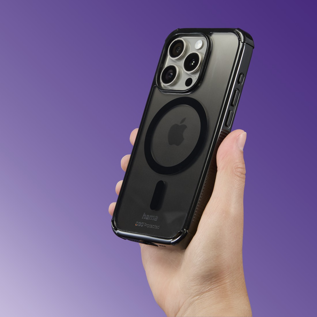 Hand hält schwarzes iPhone in Schutzhülle vor violettem Farbverlauf.
