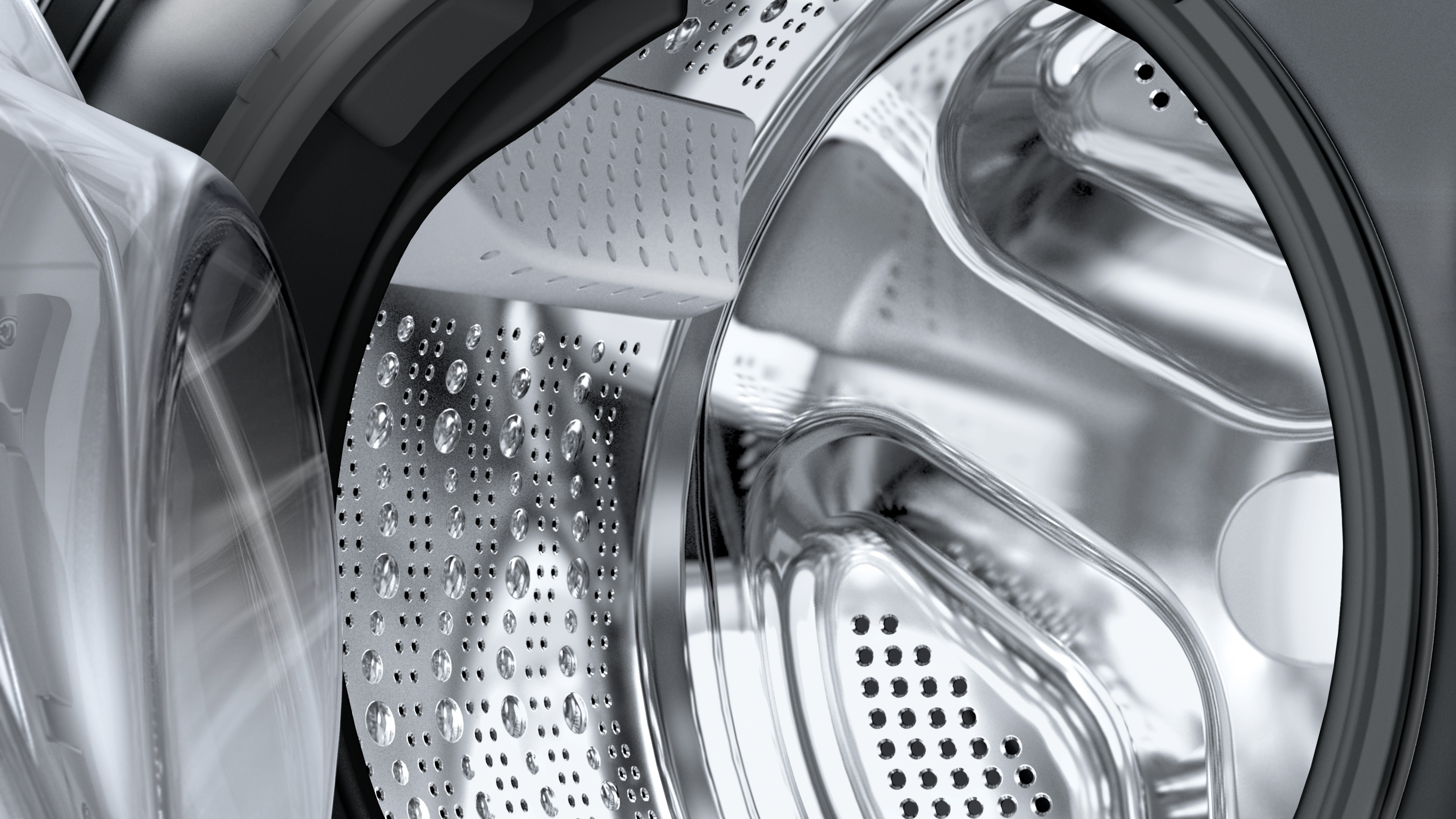 Nahaufnahme einer Waschmaschinentrommel. Glänzende Metalloberfläche mit Perforationen und Wassertropfen. Schwarze Akzente und transparente Tür.