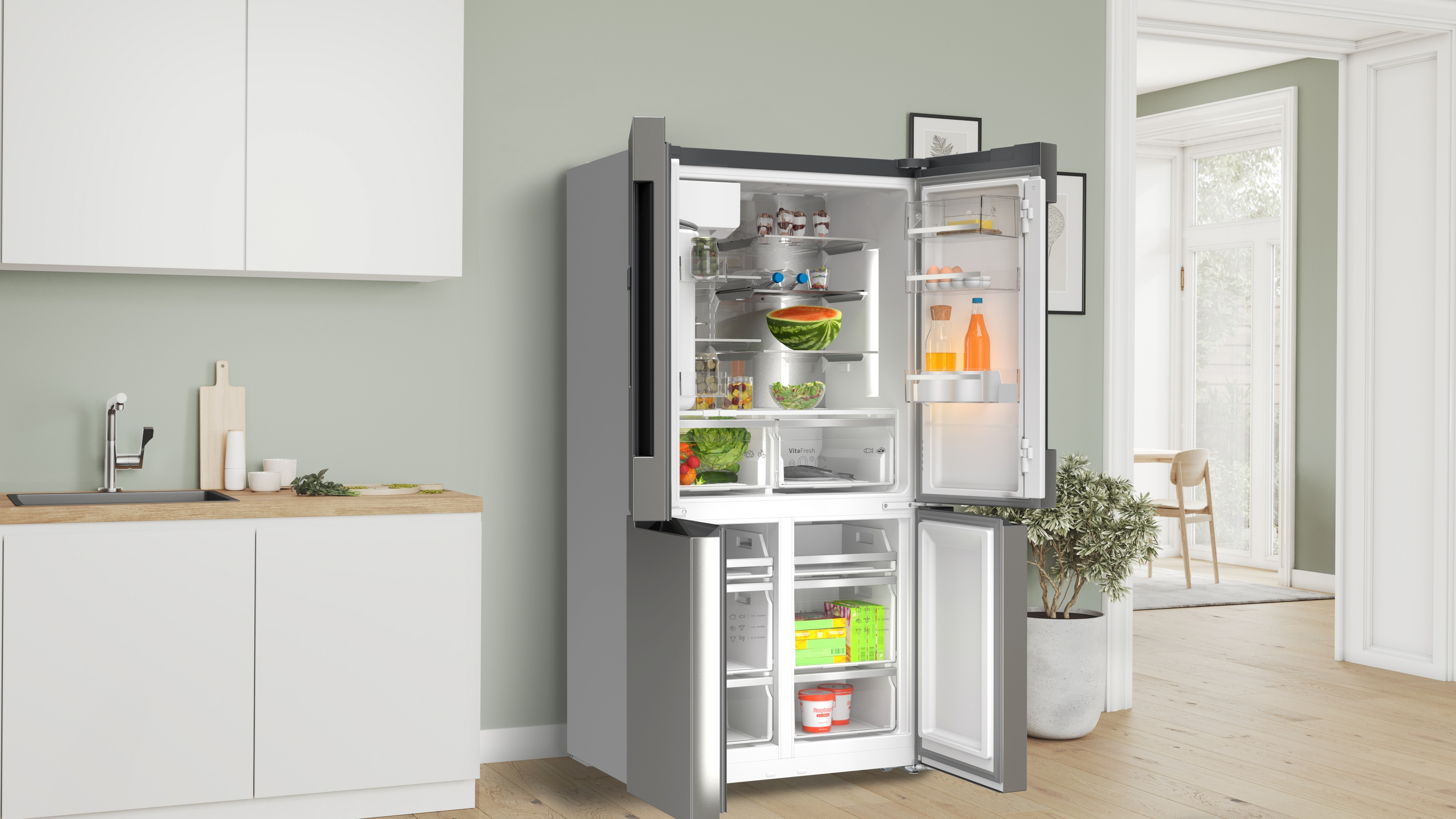 Ein moderner Kühlschrank mit offenen Türen, der Lebensmittel wie Wassermelone, Eier und Flaschen zeigt. Links eine Küchenzeile mit Spüle.