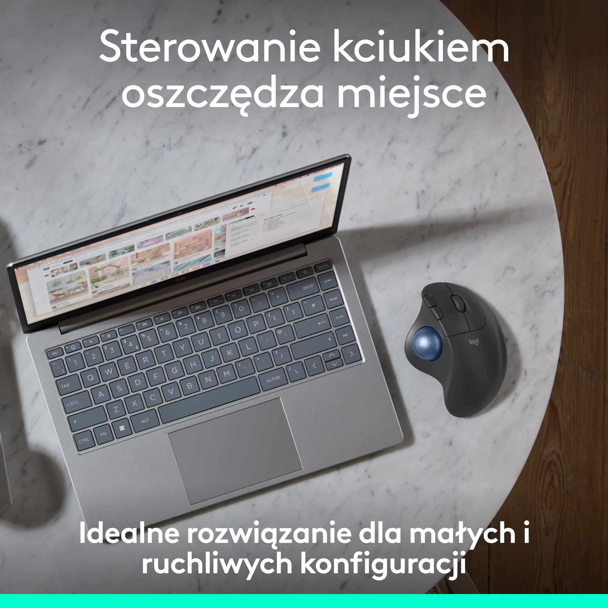 Laptop i mysz kulkowa na marmurowym stole. Tekst: Sterowanie kciukiem oszczędza miejsce.