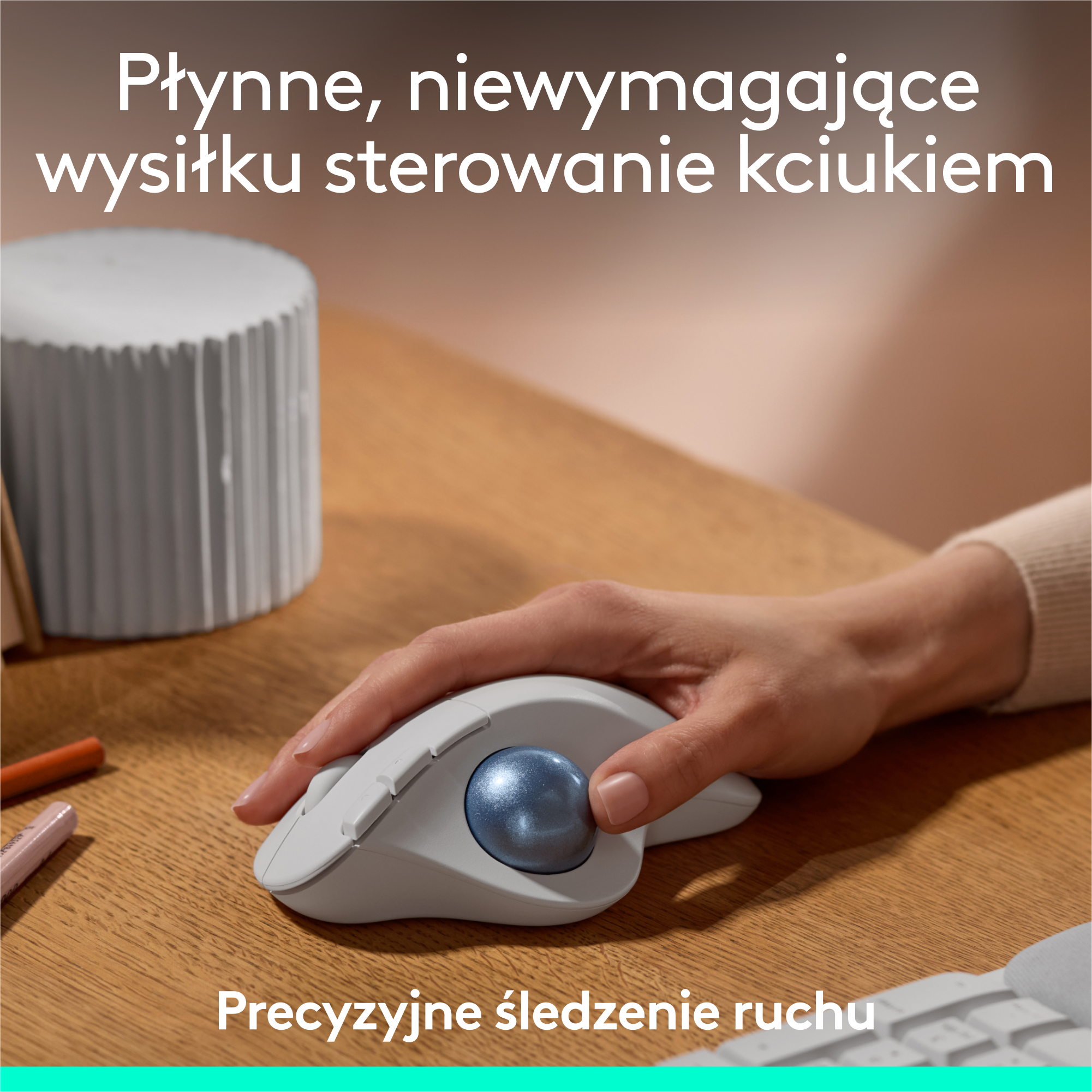 Dłoń na białej myszy z niebieską kulką. Tekst u góry mówi: Płynna, bezproblemowa kontrola kciukiem.
