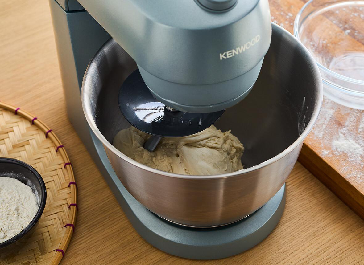 Kenwood Küchenmaschine in Aktion, Teig in Metallschüssel mischen.