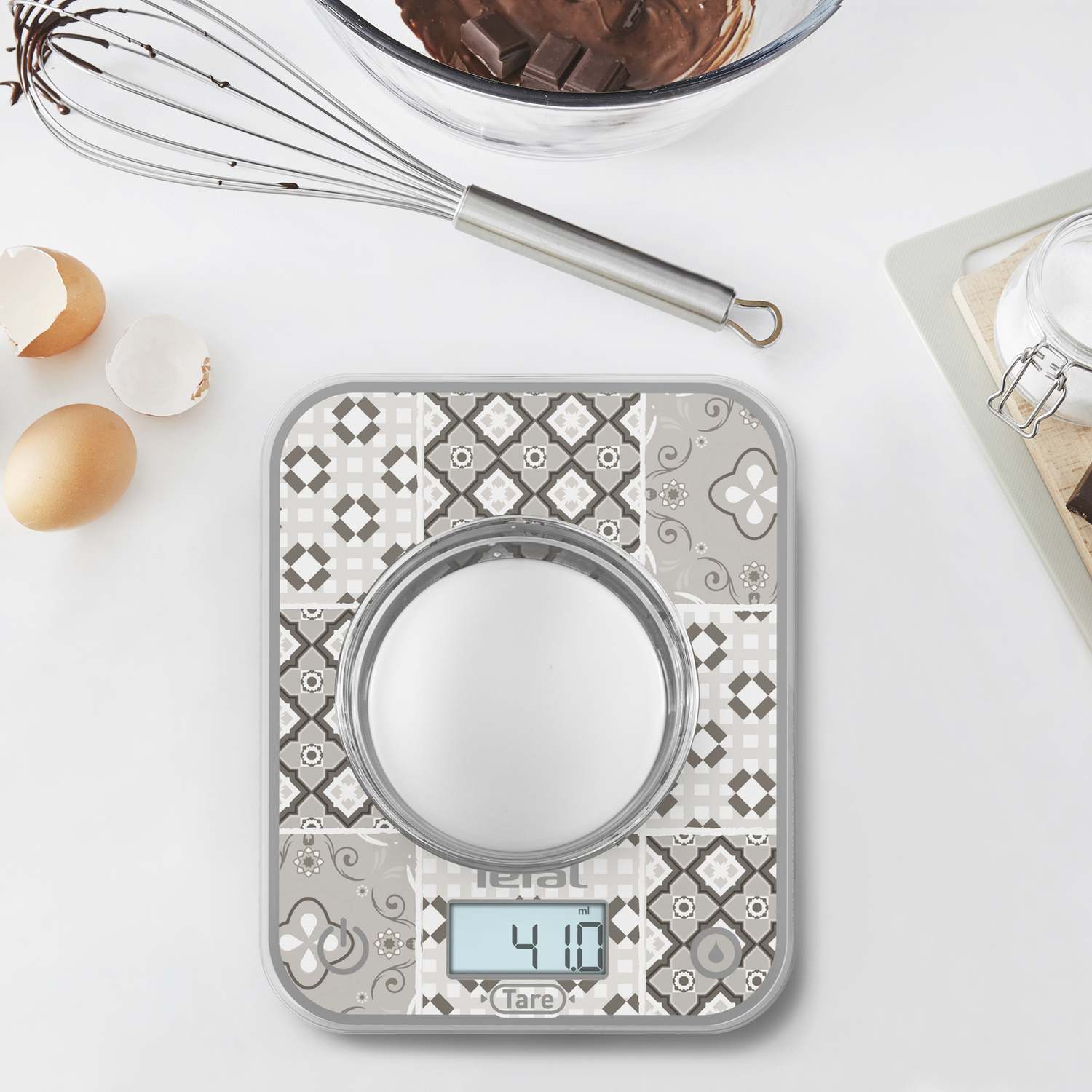 Une balance de cuisine avec une surface à motifs, affichant un affichage numérique du poids.
