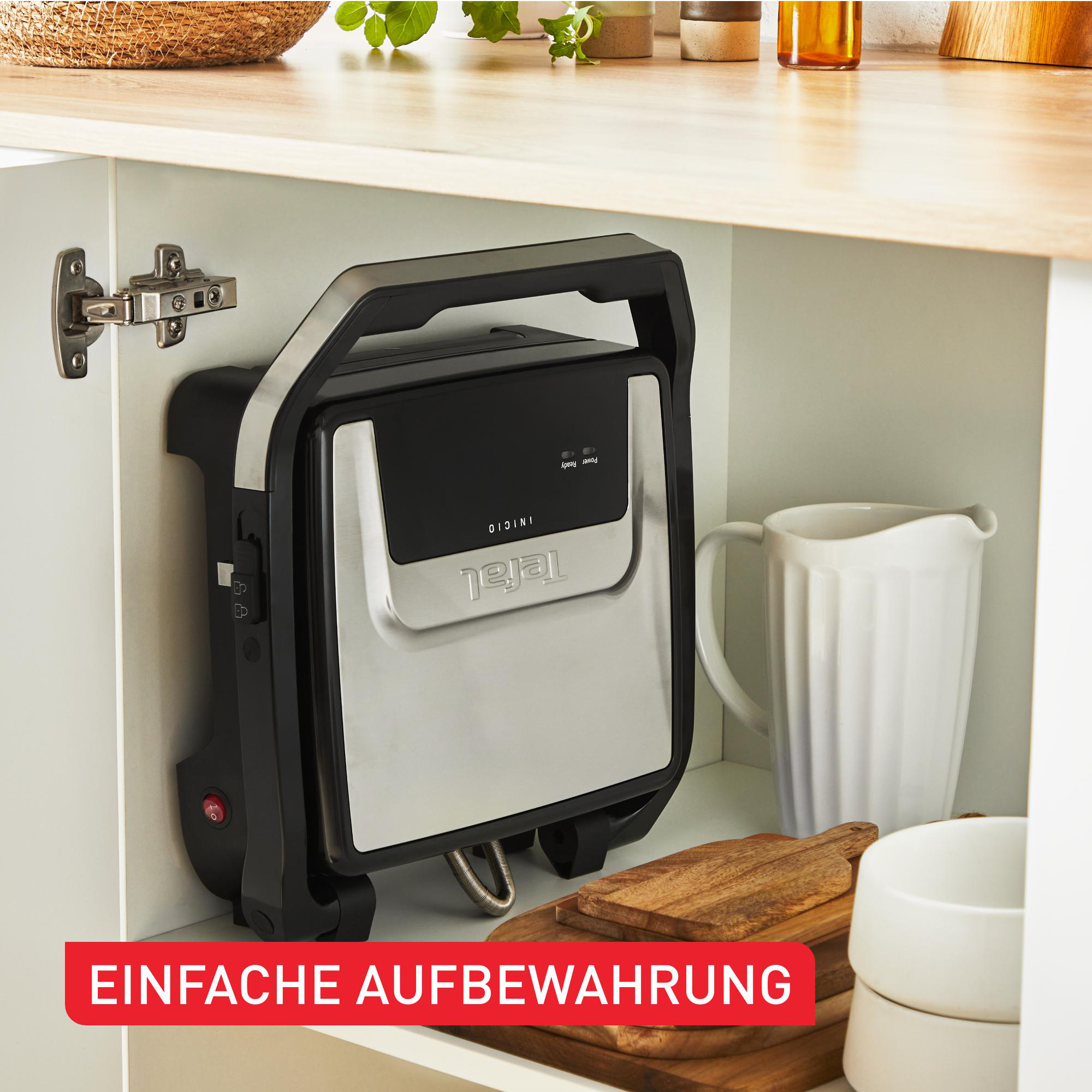 Ein zusammengeklappter Tefal-Grill, der in einem Küchenschrank aufbewahrt wird.