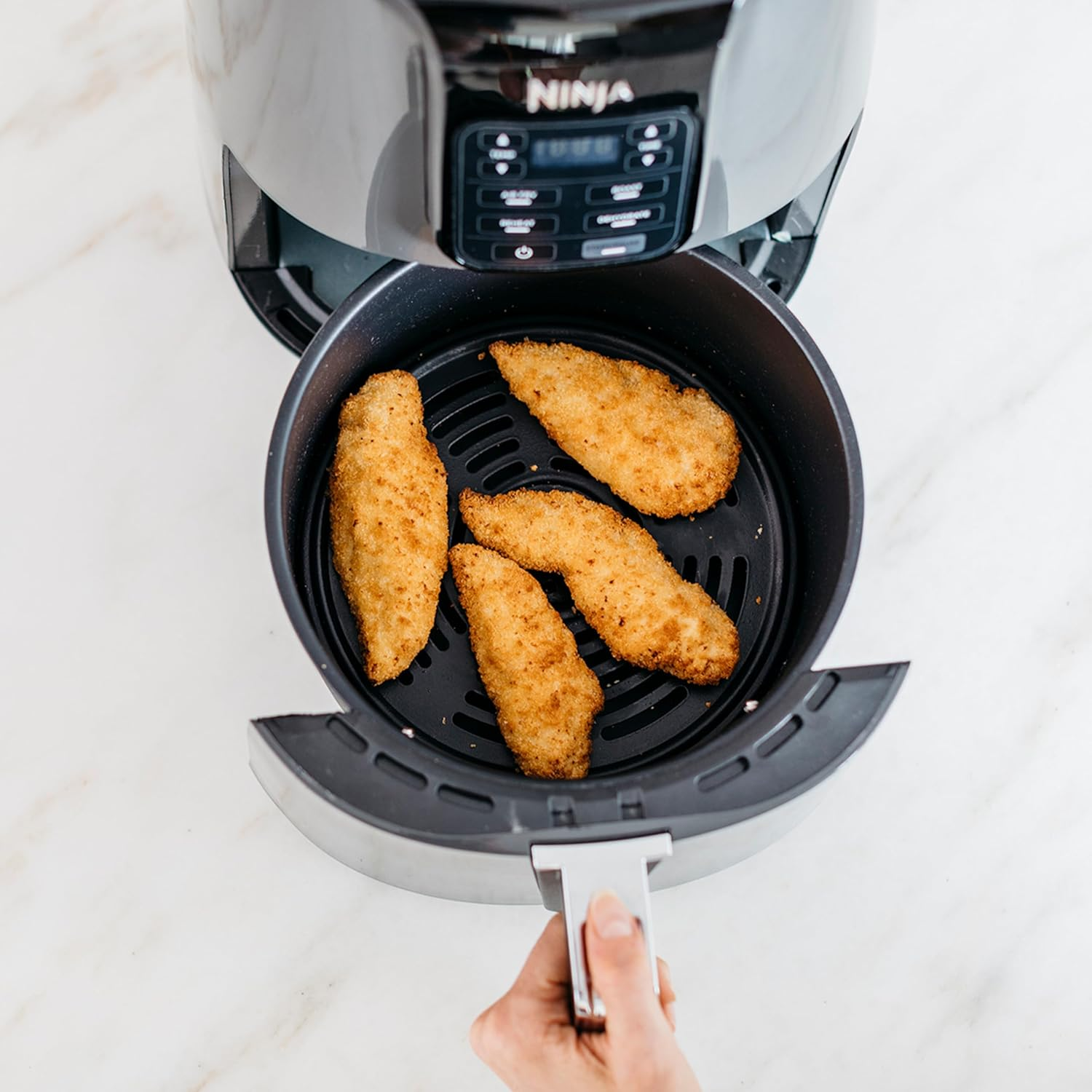 Felülnézet sült csirkéről egy fritőz kosárban.