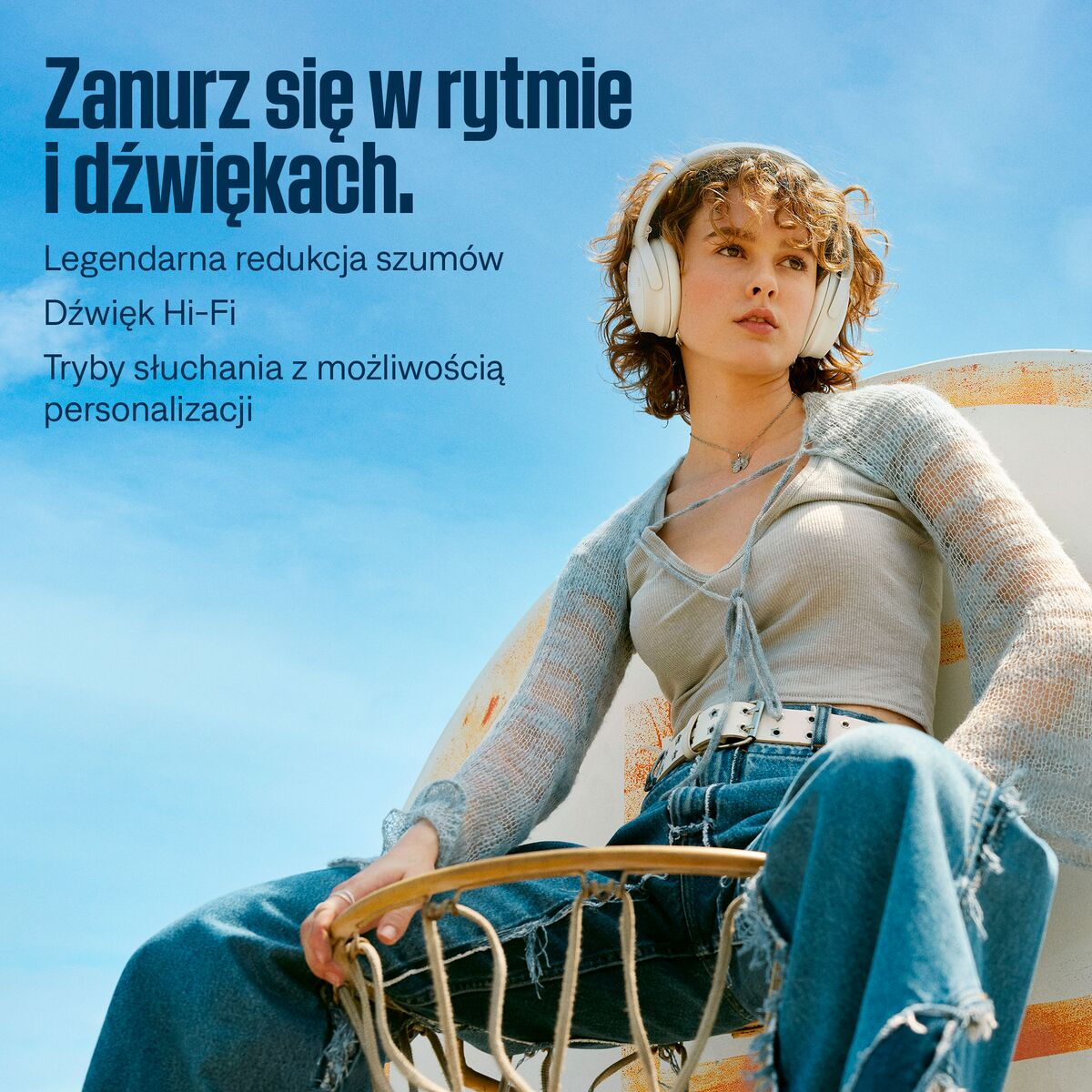 Kobieta z białymi słuchawkami, niebieskie niebo w tle.