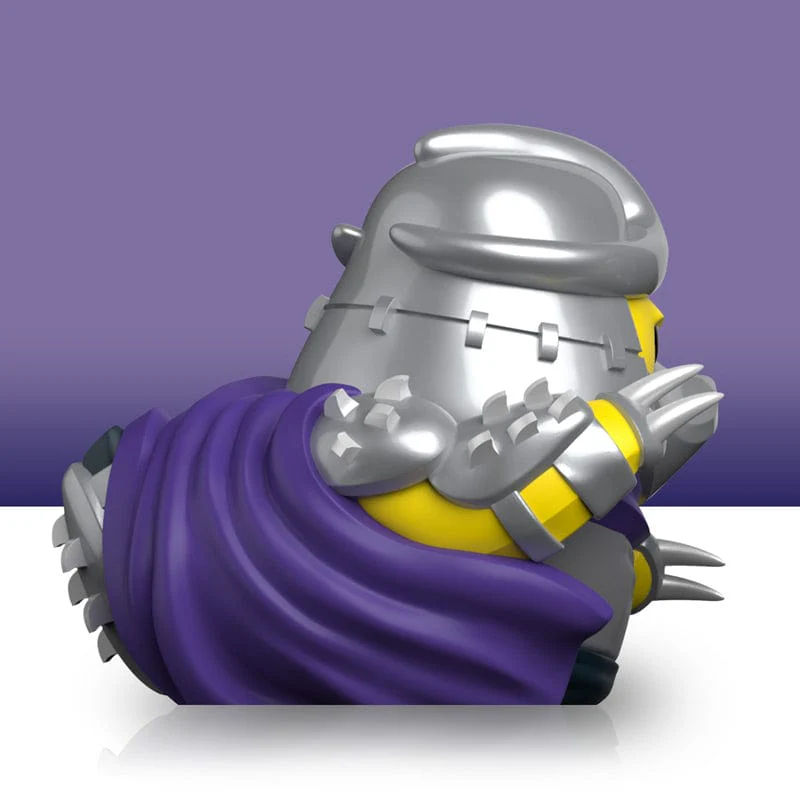 Shredder kacsafigura, oldalsó nézet. Ez egy rajzfilmszerű kacsa ezüst sisakkal és lila köpennyel.