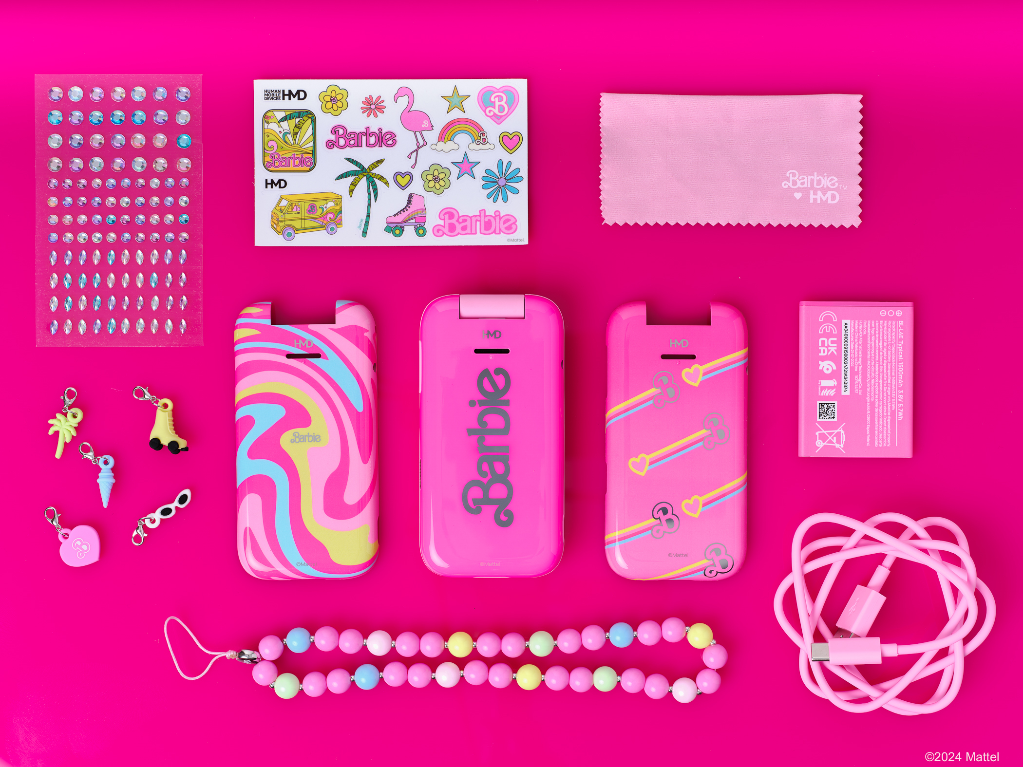 Barbie témájú telefontartozékok, beleértve a telefonokat, matricákat, medálokat és egy rózsaszín töltőkábelt.