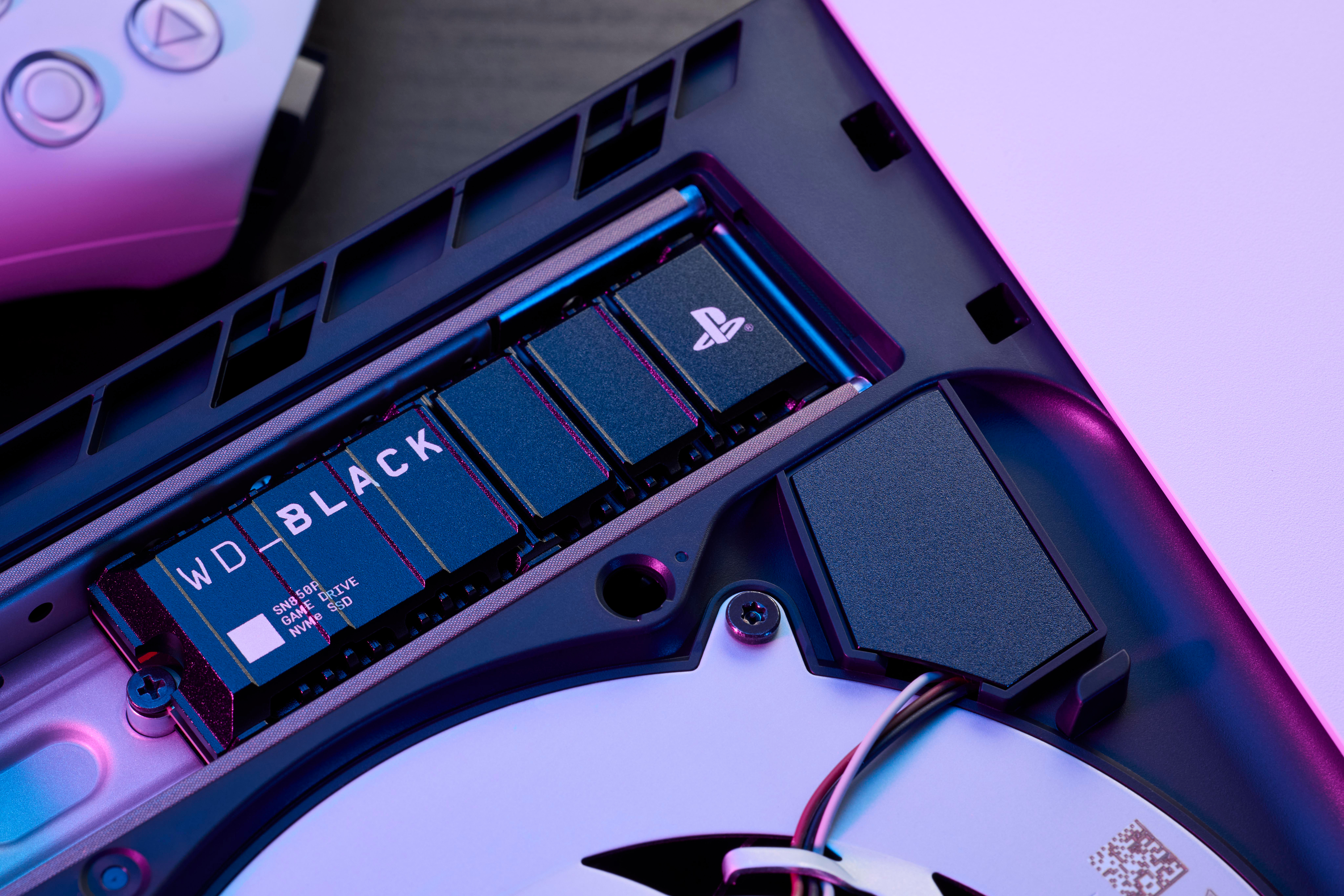 Geöffnete Spielekonsole mit interner SSD mit der Aufschrift WD_BLACK. PS-Symbol sichtbar.