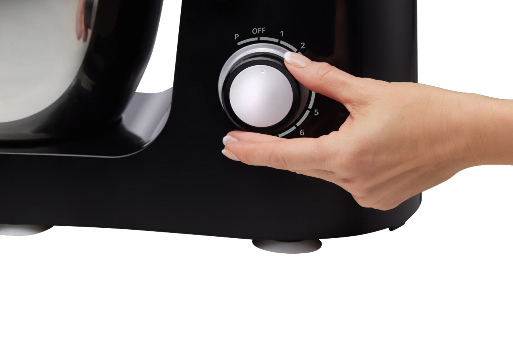 Egy kéz egy fekete konyhai mixer tárcsáját forgatja. A tárcsán számok és egy kikapcsolt pozíció található. A háttér fekete.