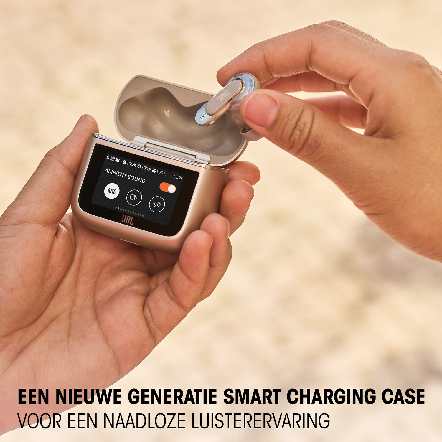 A person holding a gold charging case with earbuds. The case has a screen displaying information.