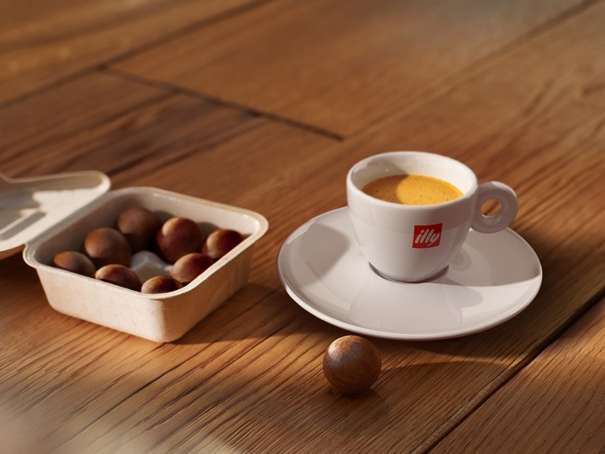 Tasse et soucoupe à café avec noix sur table en bois.