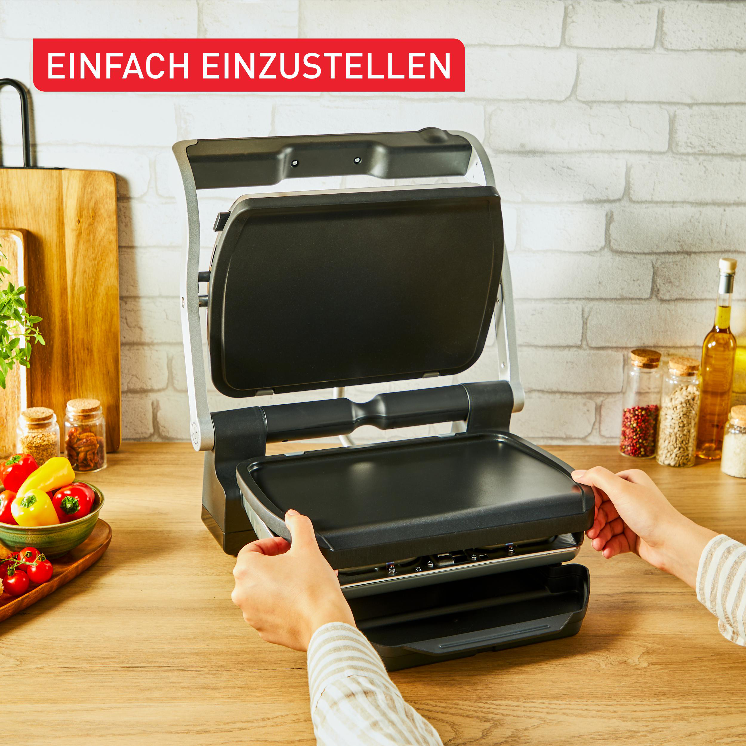 Hände benutzen einen Grill. Der Grill ist geöffnet.