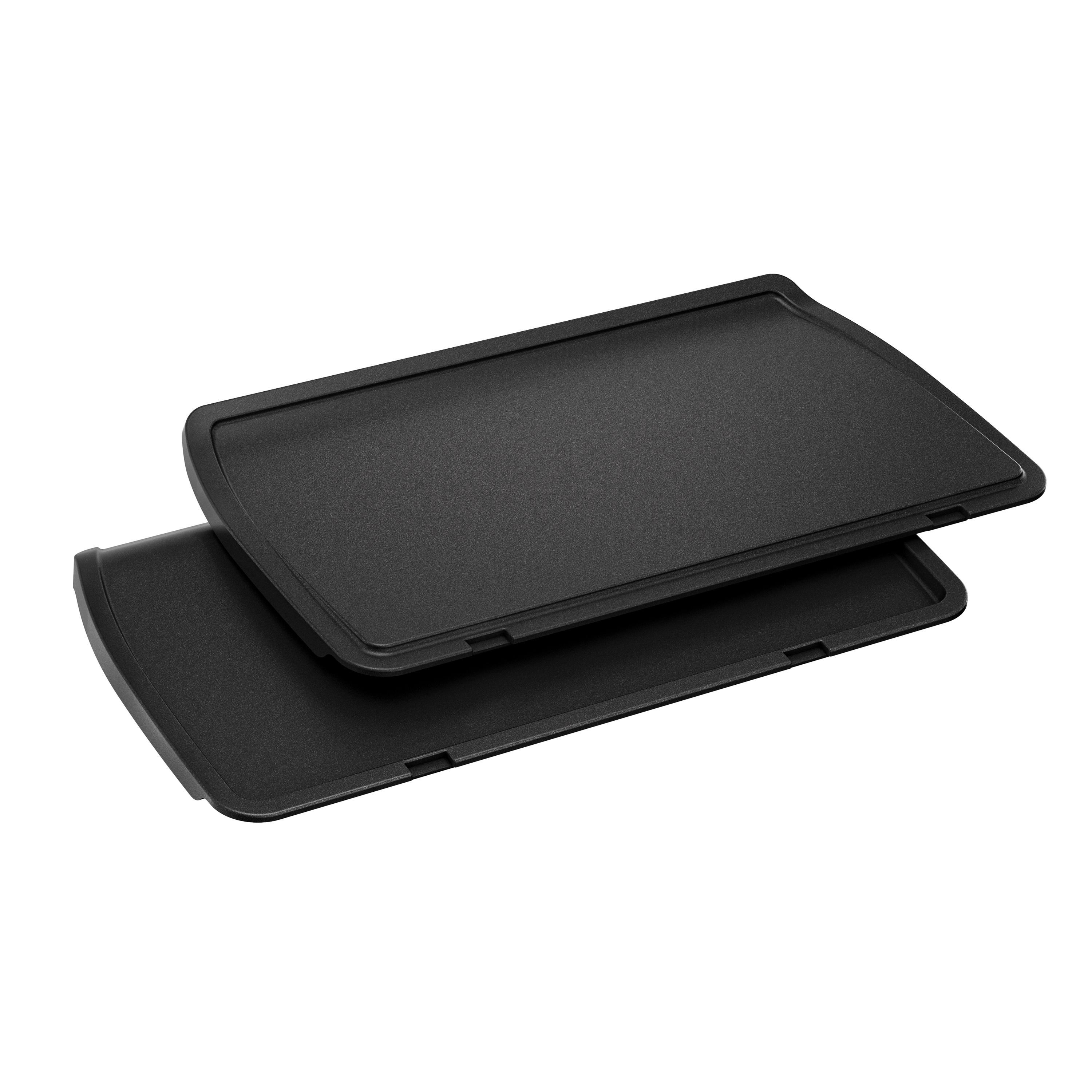 Zwei schwarze Grillplatten. Sie sind rechteckig mit leicht gebogenen Kanten.