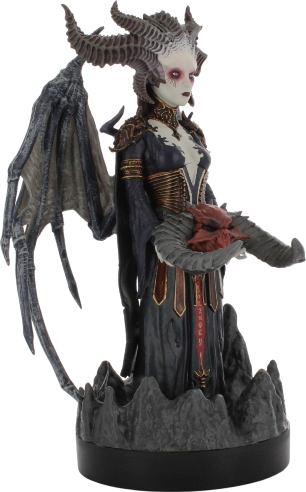 Dämonenfrau-Statue, die ein rotes Objekt auf einem felsigen Sockel hält.