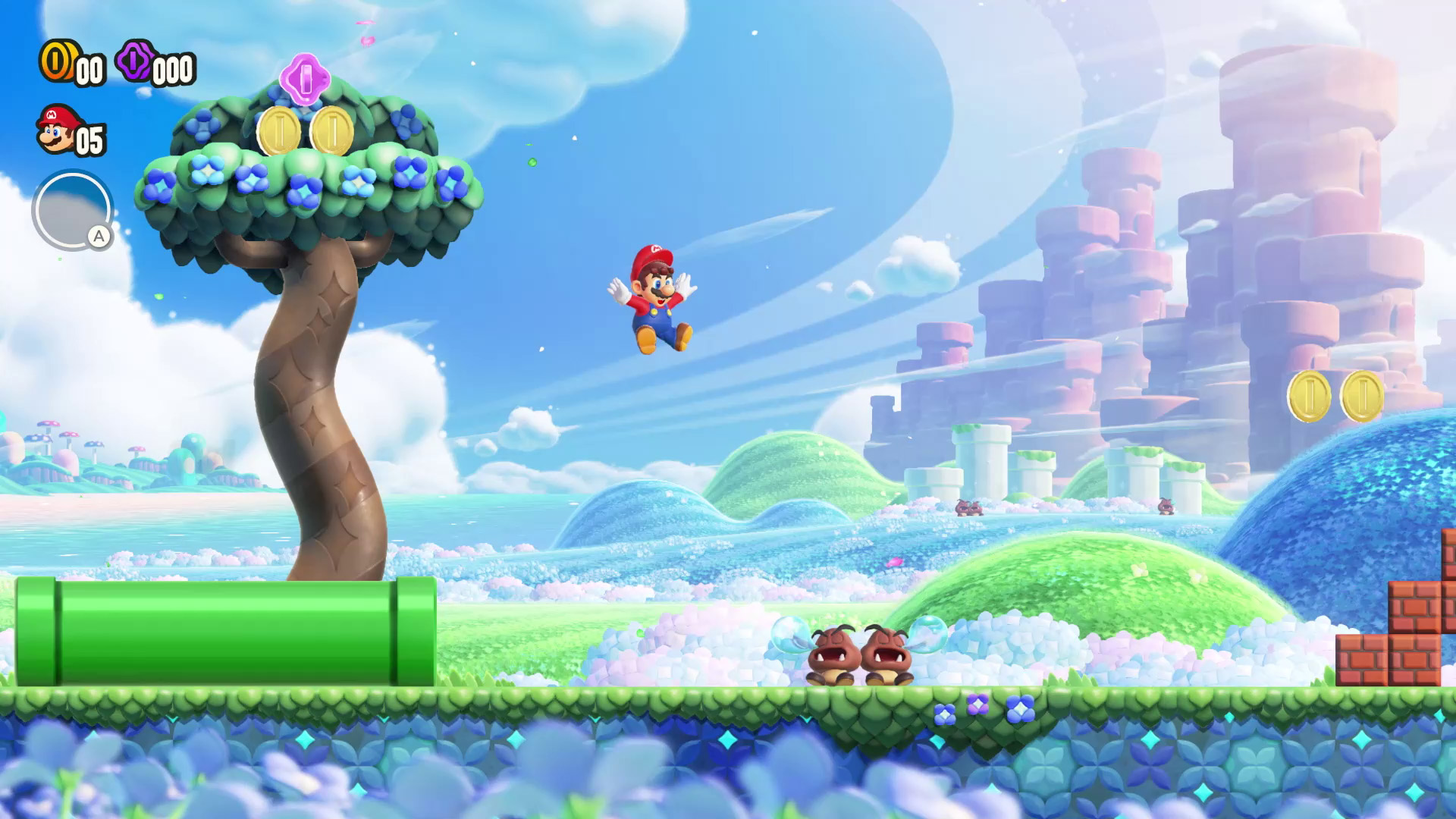 Mario springt in einer farbenfrohen Spielszene. Es gibt Plattformen, Feinde, Münzen und einen Baum.