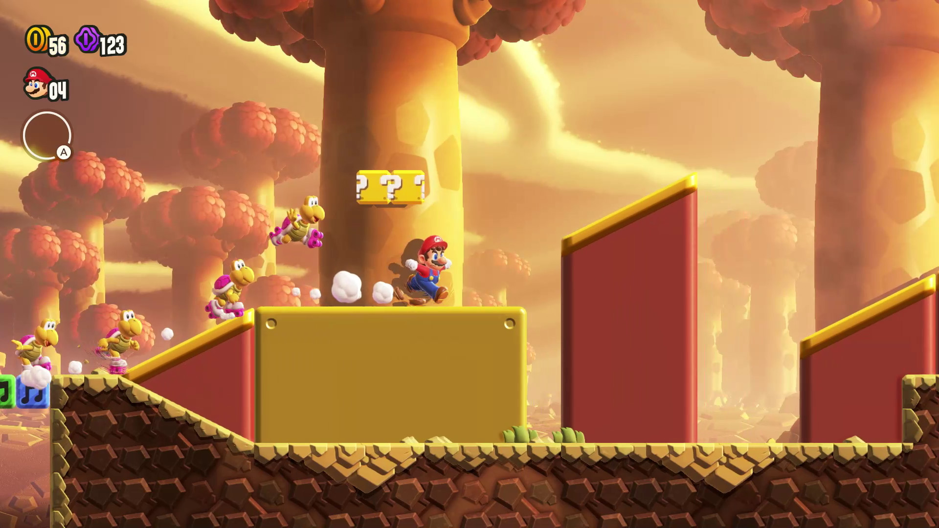 Mario rennt auf Plattformen in einem Videospiel, mit Feinden und Fragezeichenblöcken in goldener Umgebung.