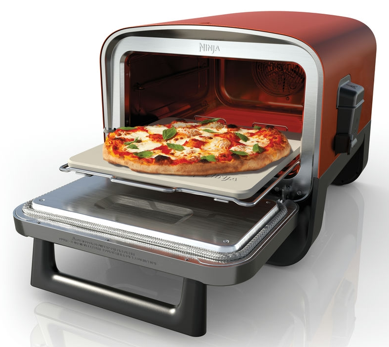 Piros Ninja pizzasütő pizzával a kövön. A sütő nyitva van. Fehér háttér.