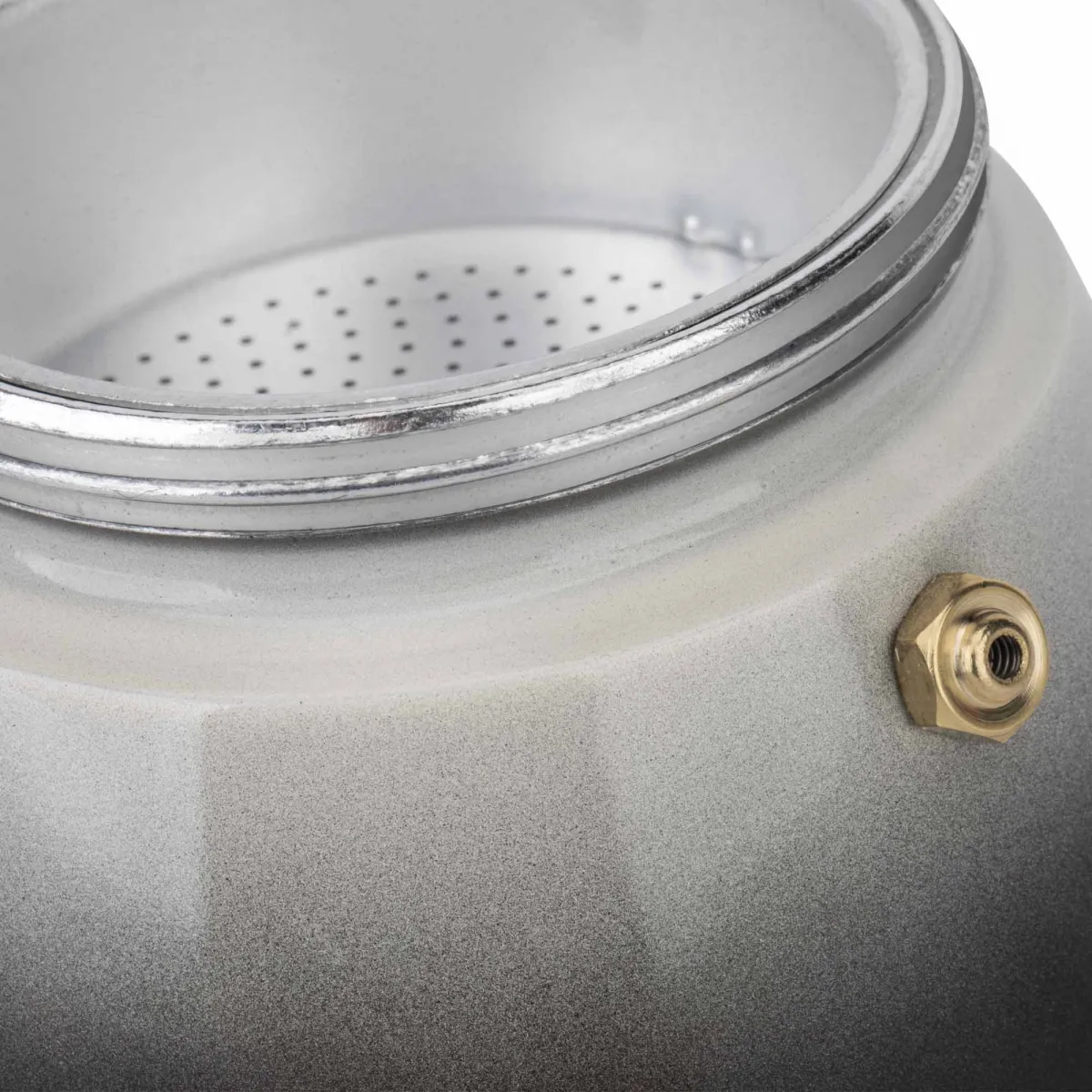 Primer plano de una cafetera moka plateada. Parte superior con agujeros, tornillo de latón lateral.