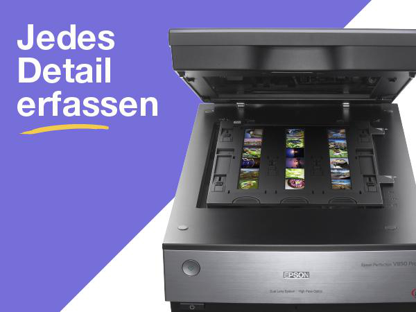 Scanner mit offenem Deckel. Das Bild zeigt mehrere Fotos, die gescannt werden sollen.