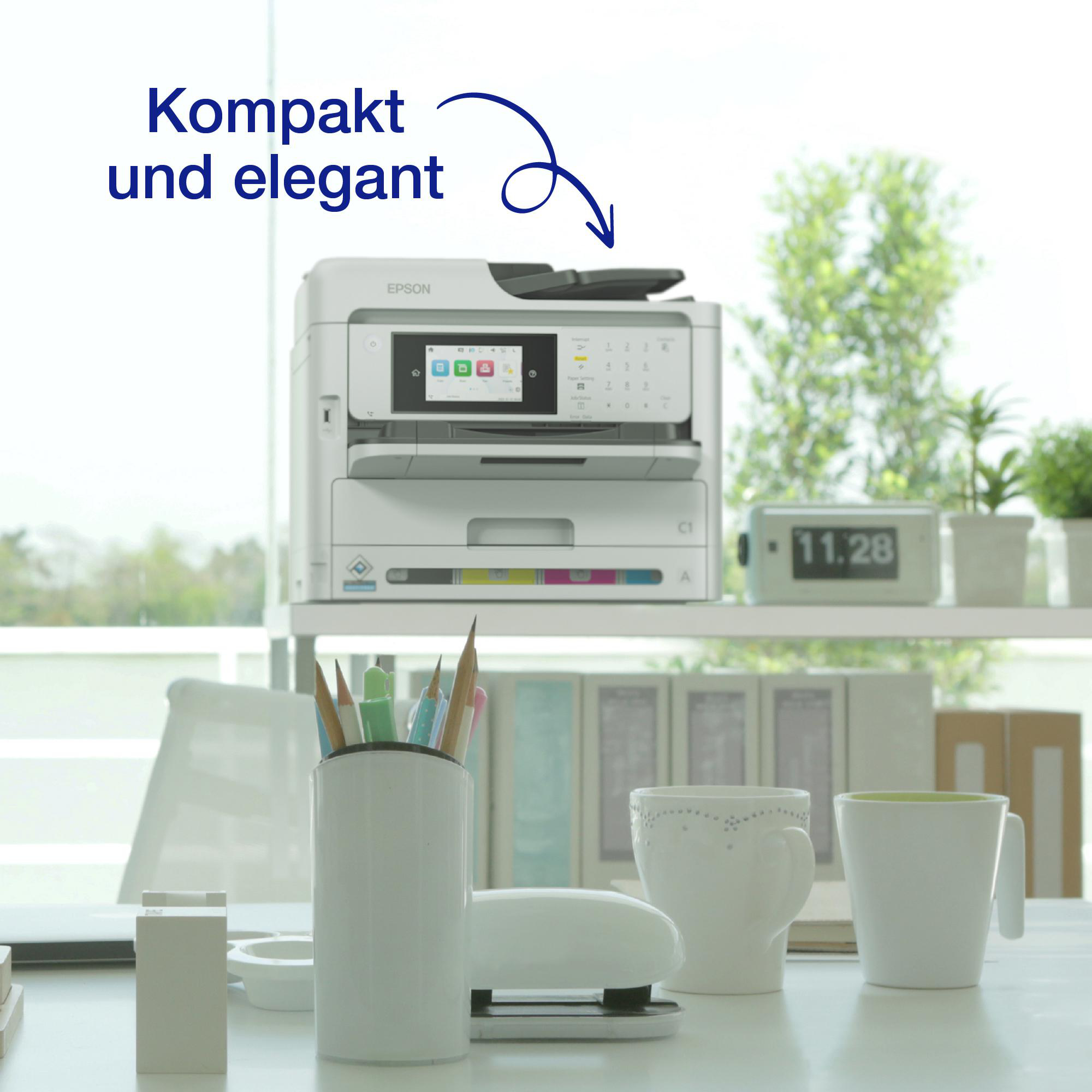 Epson Drucker, mit Text 'Kompakt und elegant', auf einem Schreibtisch mit Objekten.