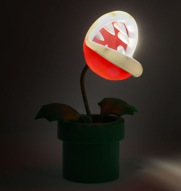 Eine Piranha-Pflanzenlampe in einem grünen Rohr, mit rotem und weißem Kopf.