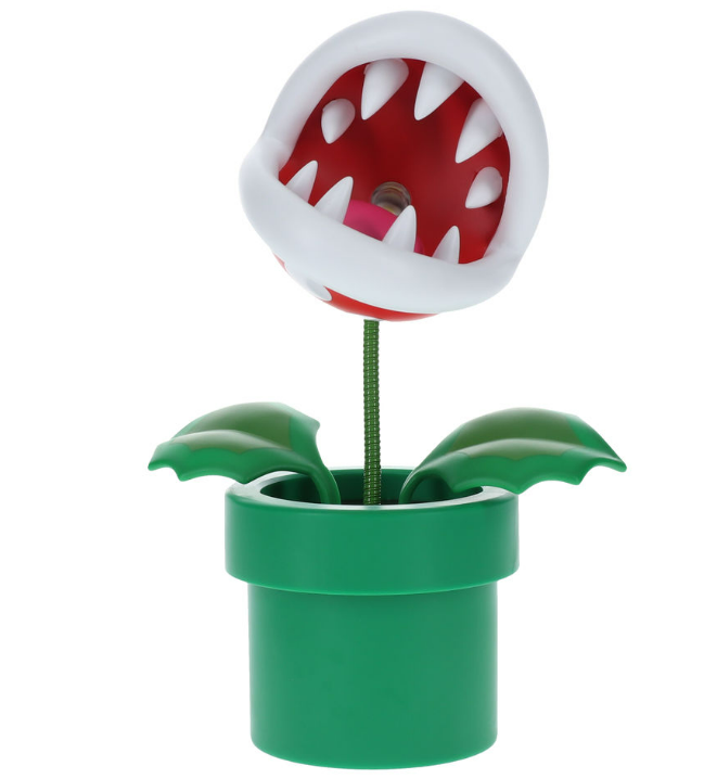 Piranha Pflanze Spielzeug in einem grünen Topf, weiße Zähne, roter Mund, grüne Blätter.