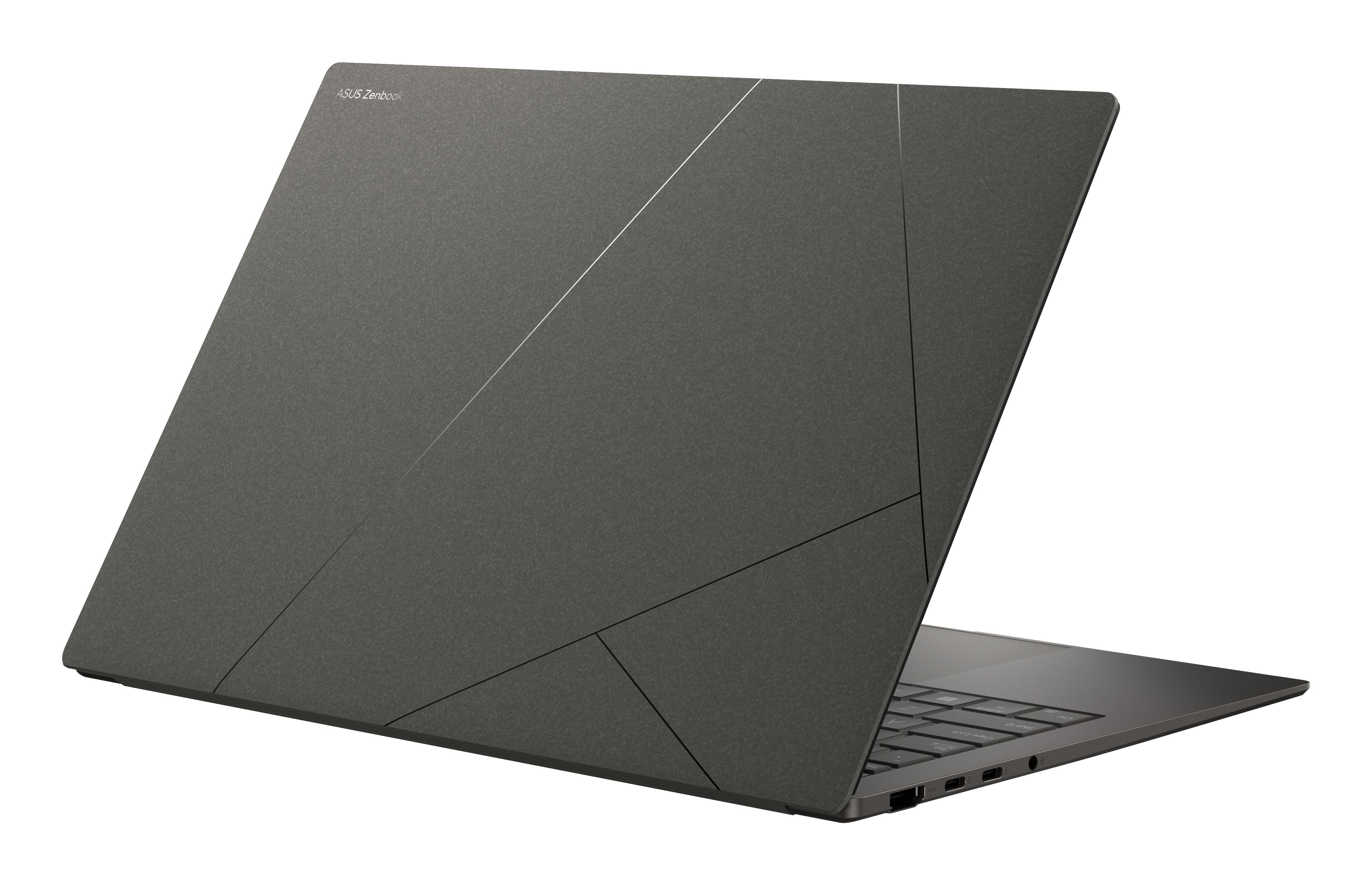 Ein dunkelgrauer Laptop mit einem geometrischen Muster auf der Rückseite, vor einem weißen Hintergrund.