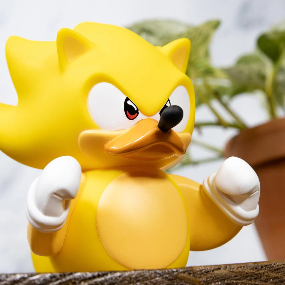 Egy sárga Super Sonic figura dühös arckifejezéssel, zöld növény háttérrel.