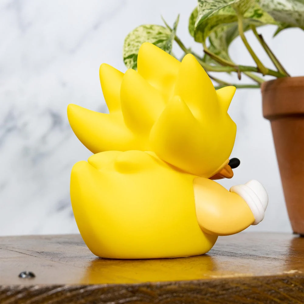 Sárga Sonic a Sündisznó figura tüskés hajjal, fehér karral, fa felületen.
