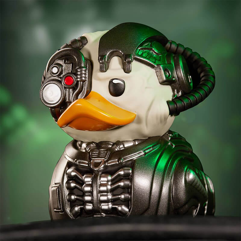 Kacsa játék cyborg dizájnnal, fém és fekete részekkel. Zöld háttér.