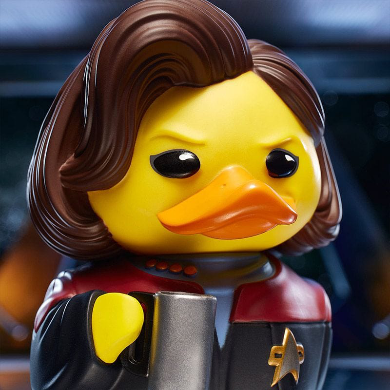 Sárga kacsafigura, mint Janeway kapitány a Star Trekből, bögrével, szigorú arckifejezéssel.