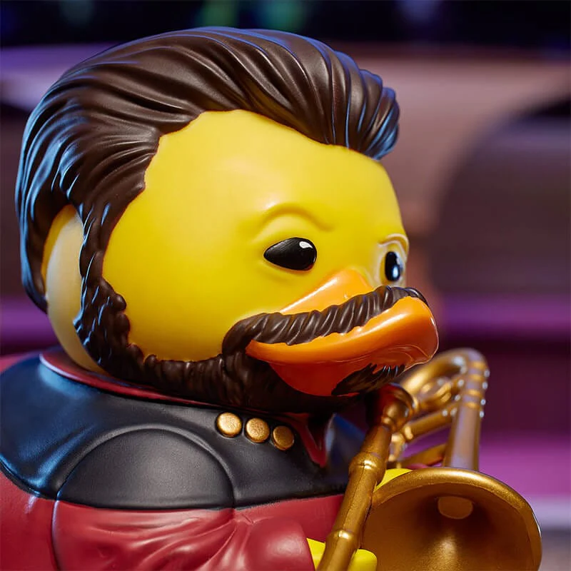 Jazz témájú gumi kacsa, sárga fej, barna haj és szakáll, arany trombitával.