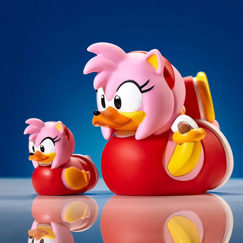 Amy Rose gumikacsák piros jelmezben. A nagy a kicsi előtt áll.