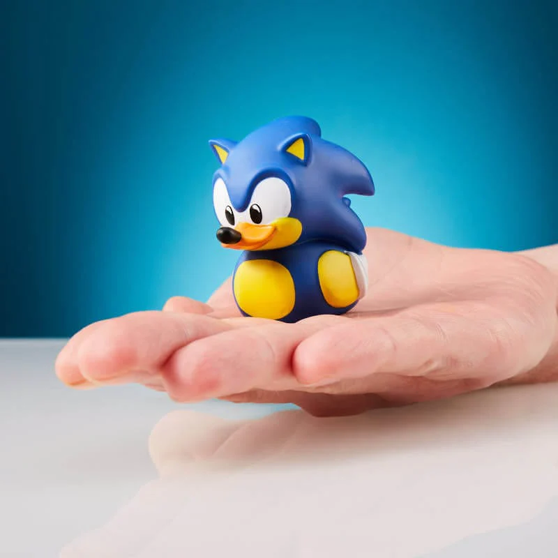 Sonic the Hedgehog játék egy kézben. A karakter kék, sárga és fehér.